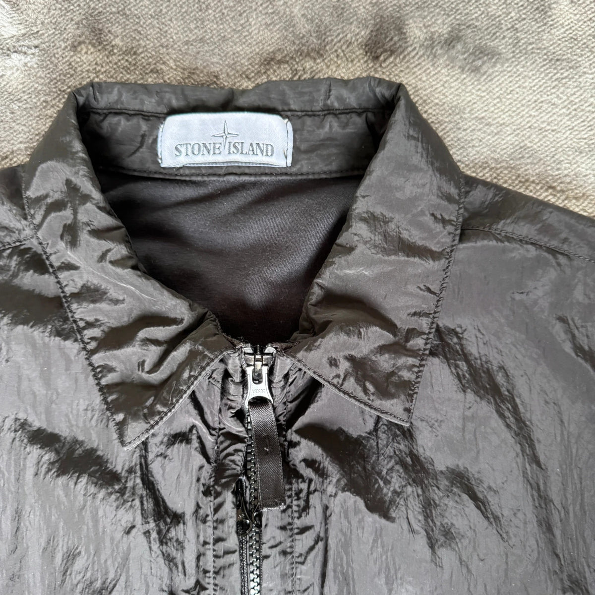 Stone Island black overshirt with logo badge and nylon metal material.