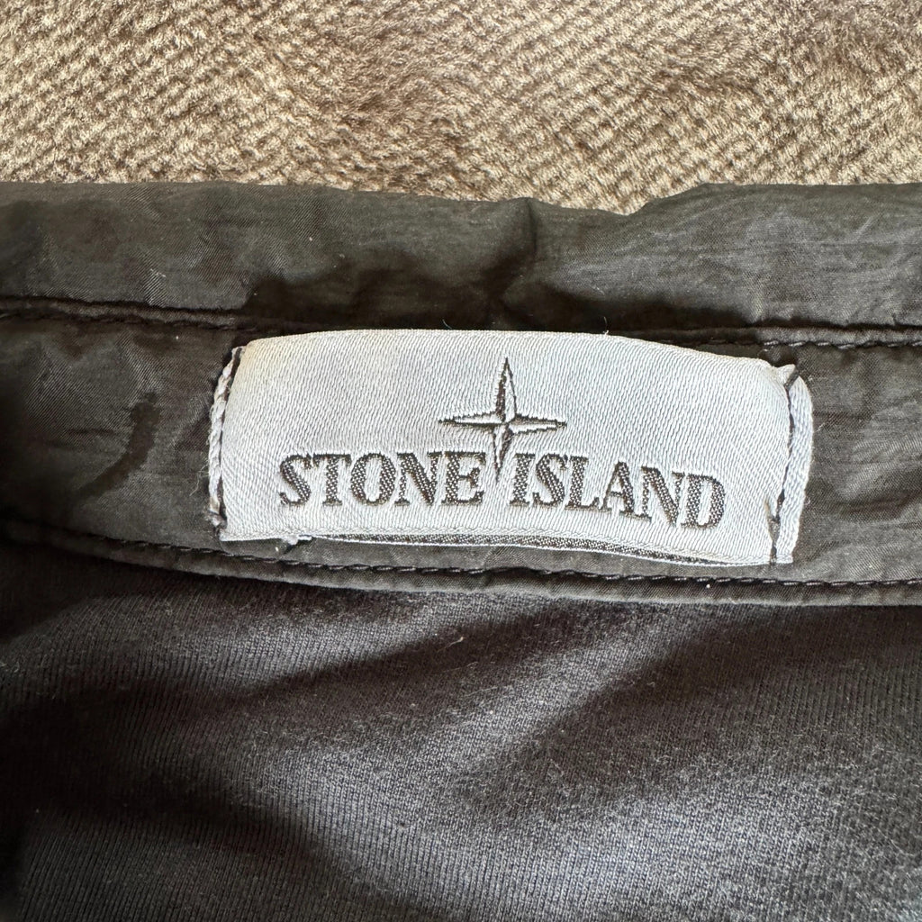Stone Island black overshirt with logo badge and nylon metal material.