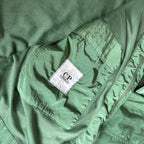 C.P. Company green overshirt with Chrome-R pocket and lens detail, brand new condition.