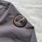 Napapijri grey pullover jacket with logo patch and ventilation zips, lightweight anorak design.