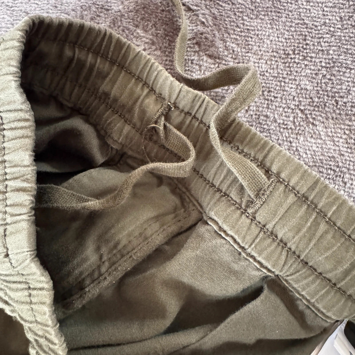 Stone Island khaki cuffed cargo trousers with logo patch and multiple pockets.
