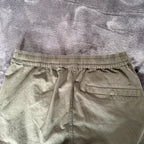 Stone Island khaki cuffed cargo trousers with logo patch and multiple pockets.