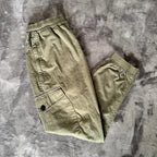 Stone Island khaki cuffed cargo trousers with logo patch and multiple pockets.