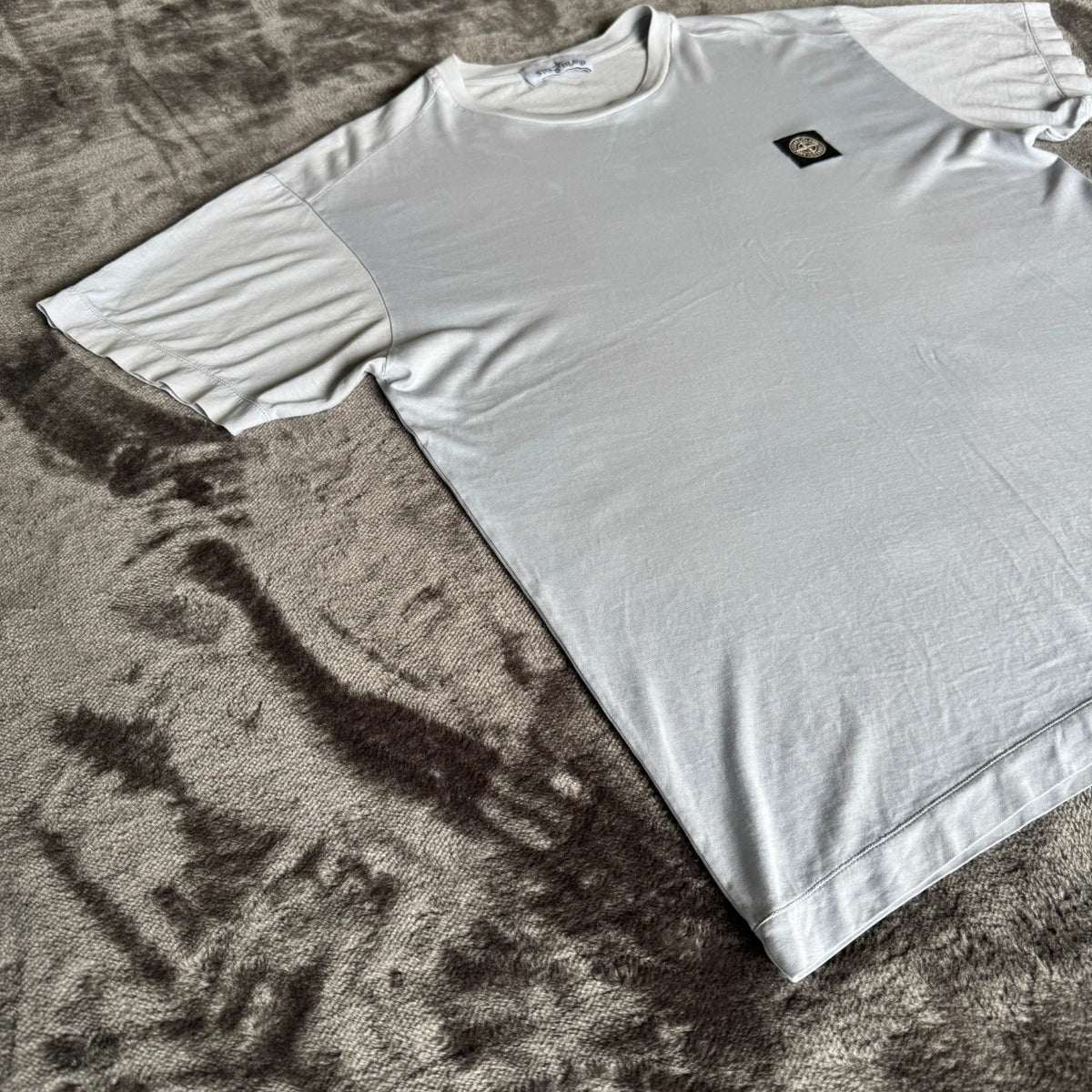 Stone Island light blue t-shirt with logo patch and crew neck design.