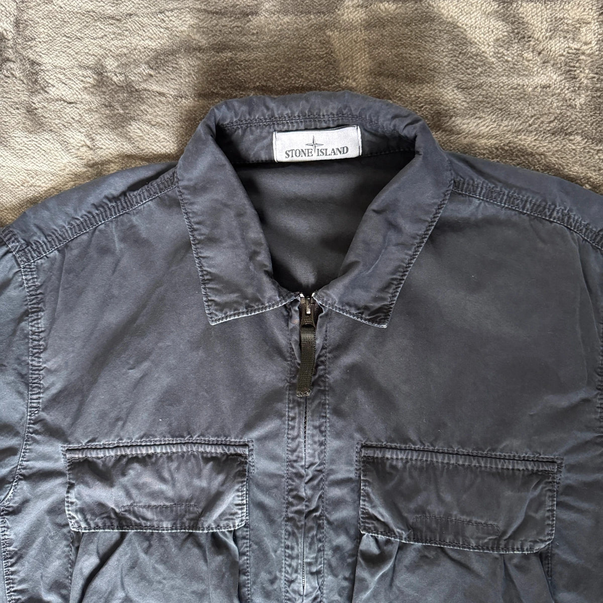 Stone Island navy overshirt featuring iconic compass logo and durable fabric.