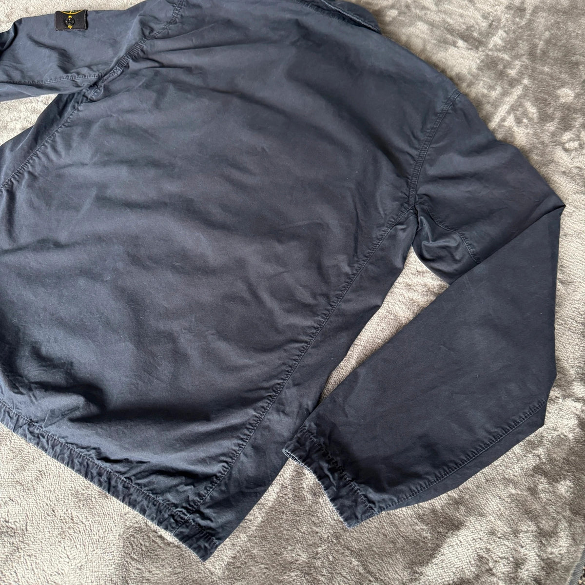 Stone Island navy overshirt featuring iconic compass logo and durable fabric.