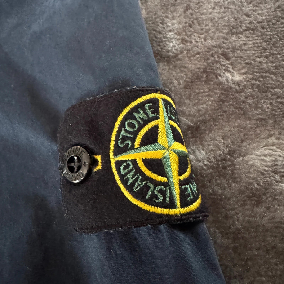 Stone Island navy overshirt featuring iconic compass logo and durable fabric.