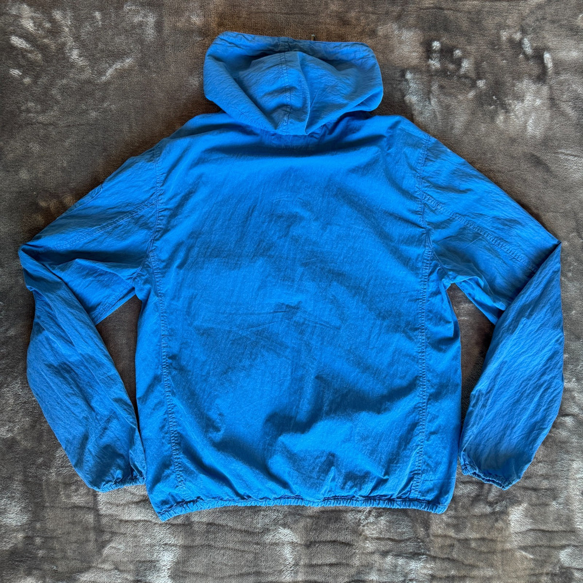 C.P. Company blue windbreaker jacket with big lens detail and garment-dyed finish.