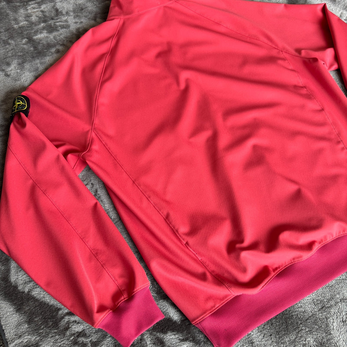 Stone Island fuchsia track jacket with logo badge and stretch nylon material.