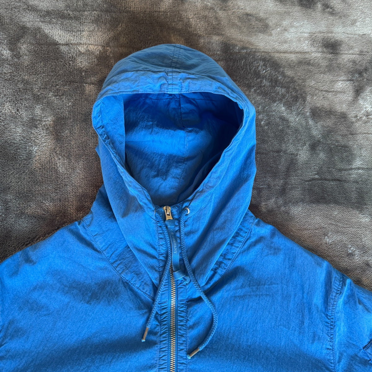 C.P. Company blue windbreaker jacket with big lens detail and garment-dyed finish.