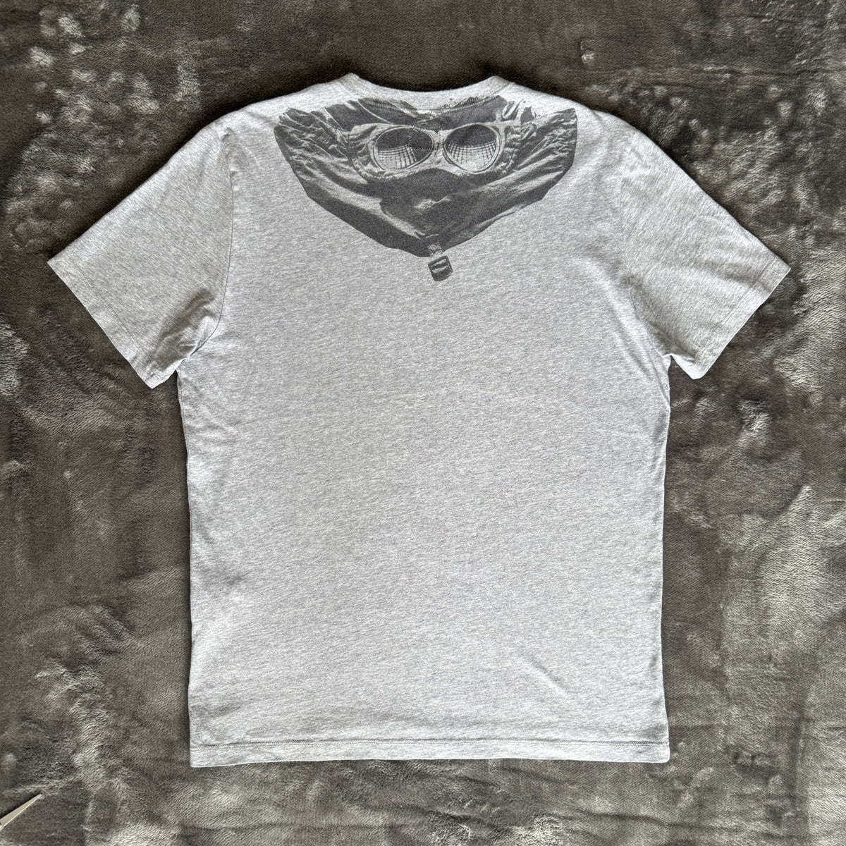 C.P. Company grey t-shirt featuring distinctive goggle print and logo detail.