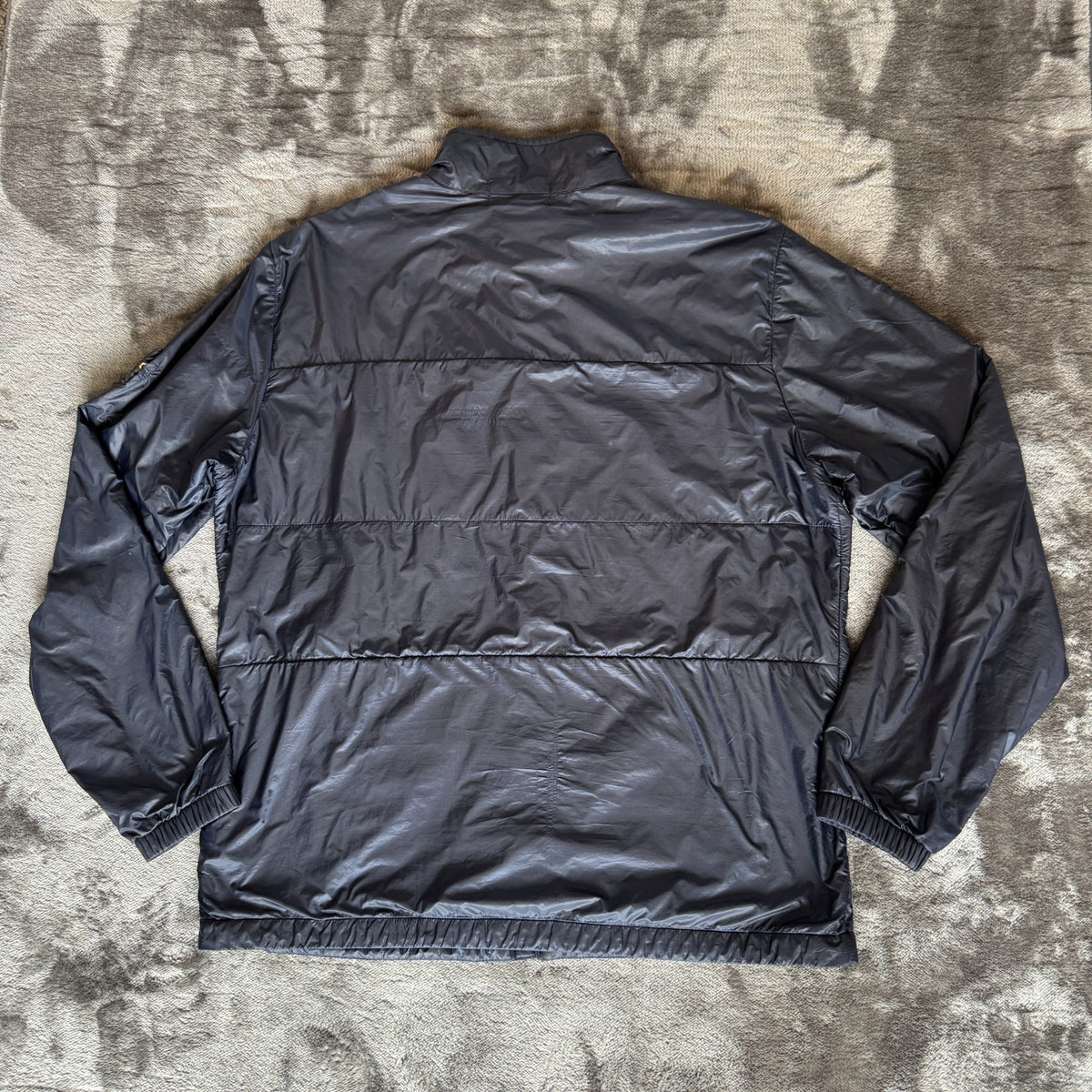 Stone Island navy quilted jacket with logo patch and micro rip stop material.