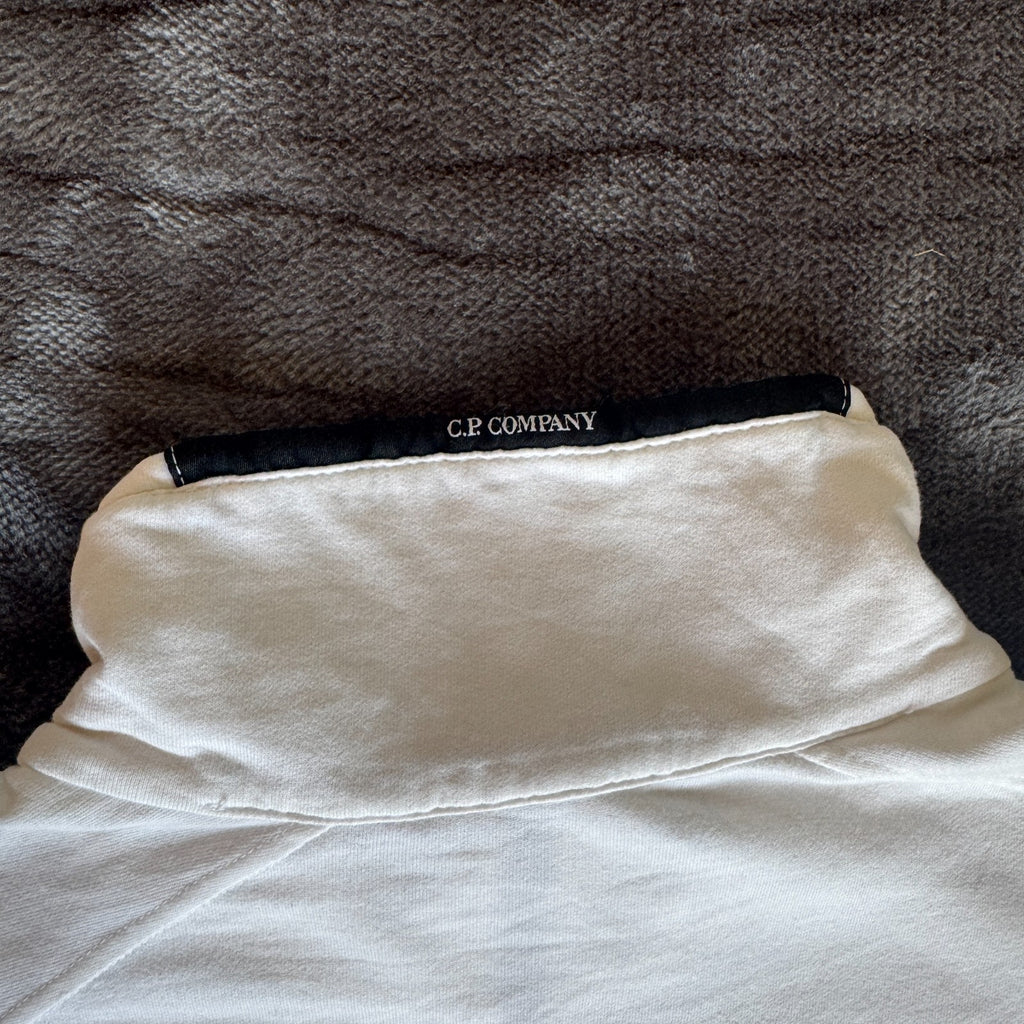 C.P. Company white quarter zip sweatshirt with logo patch and soft cotton material.