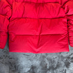 Stone Island red puffer jacket with compass patch, adjustable hood, and multiple pockets.