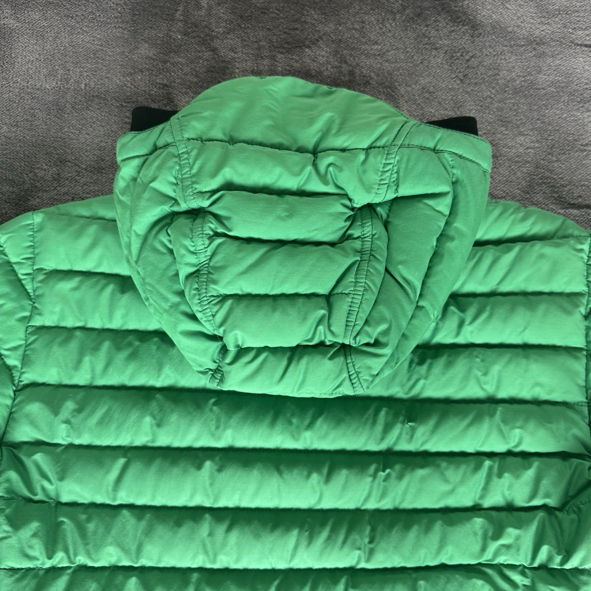 Stone Island green down jacket with logo patch and 0-cotton/R-nylon material.
