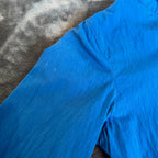 C.P. Company blue windbreaker jacket with big lens detail and garment-dyed finish.