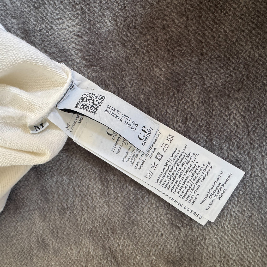 C.P. Company white quarter zip sweatshirt with logo patch and soft cotton material.