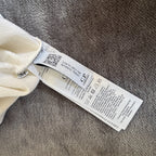 C.P. Company white quarter zip sweatshirt with logo patch and soft cotton material.