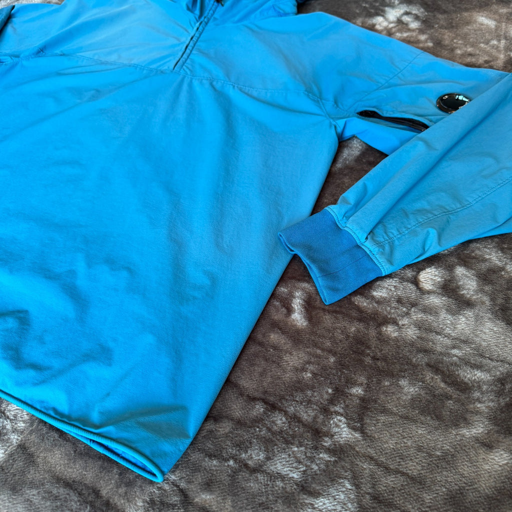 C.P. Company blue hooded smock with logo patch and Pro-Tek material details.