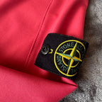 Stone Island fuchsia track jacket with logo badge and stretch nylon material.