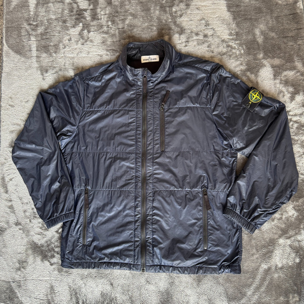 Stone Island navy quilted jacket with logo patch and micro rip stop material.
