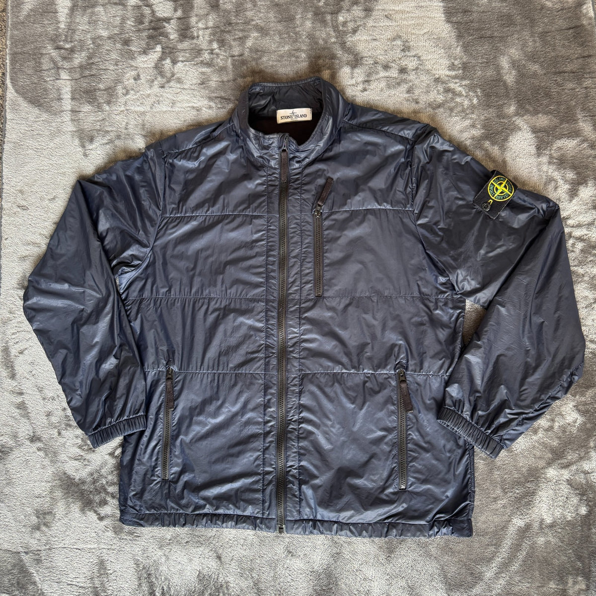 Stone Island navy quilted jacket with logo patch and micro rip stop material.