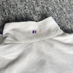 Berghaus off-white half-zip fleece with black logo pocket and stand-up collar.