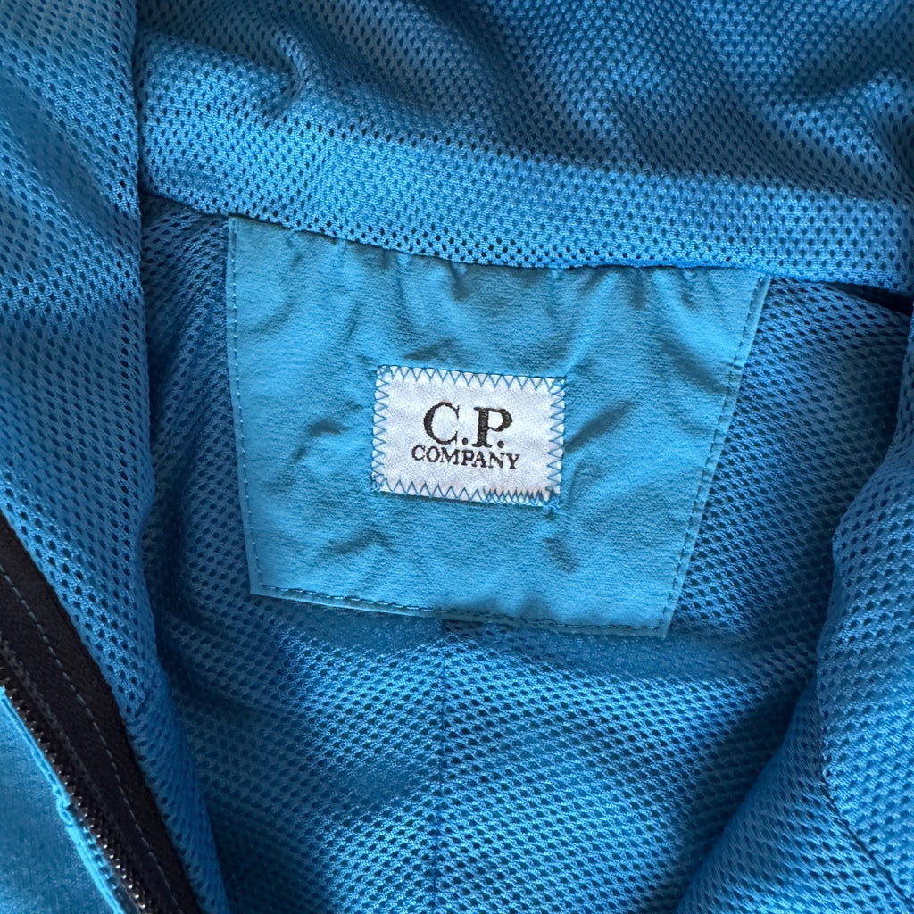 C.P. Company blue hooded smock with logo patch and Pro-Tek material details.
