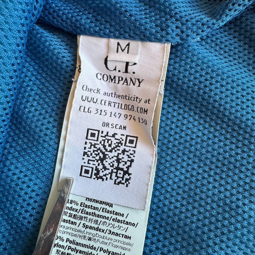 C.P. Company blue hooded smock with logo patch and Pro-Tek material details.