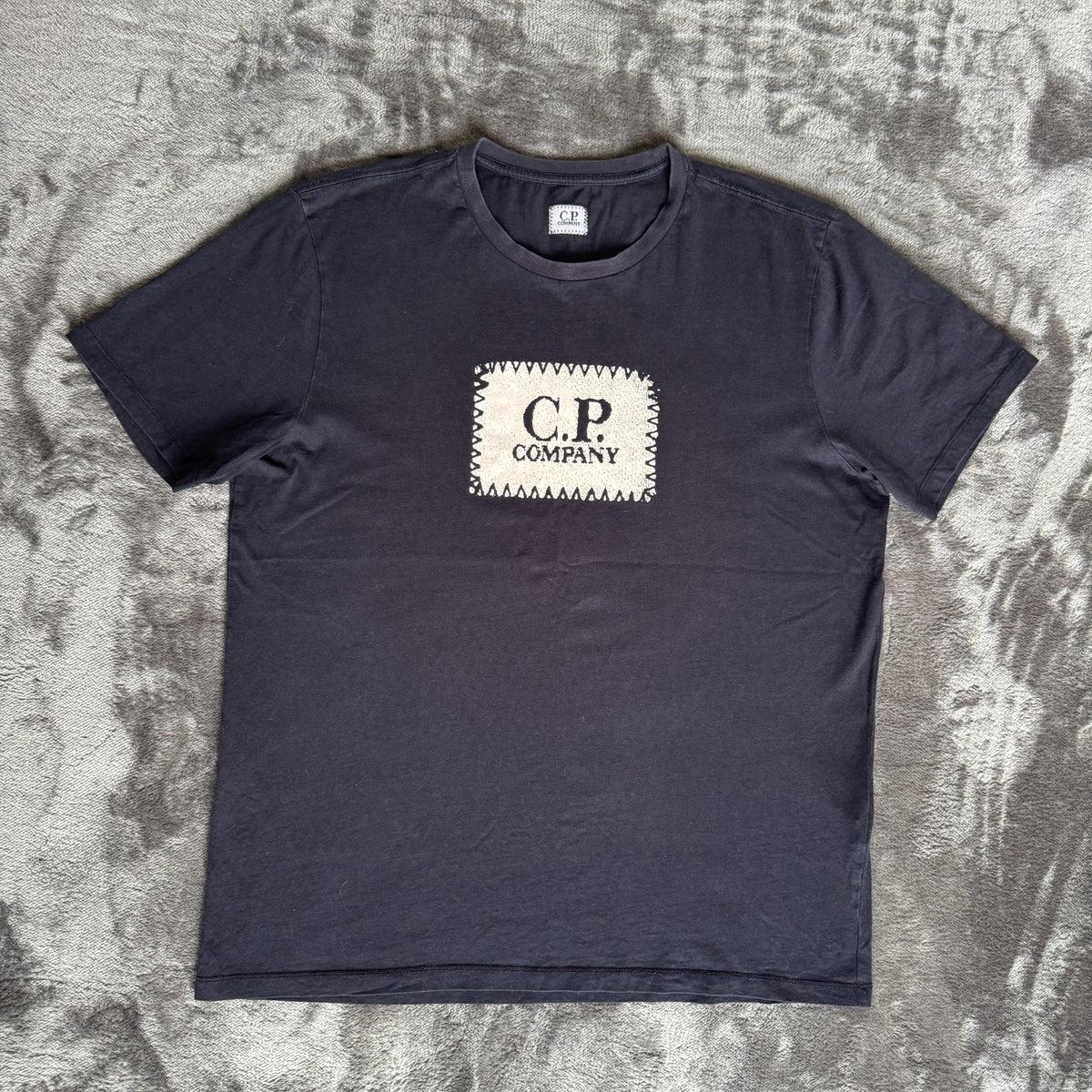 C.P. Company navy t-shirt with stamped logo and soft cotton material.