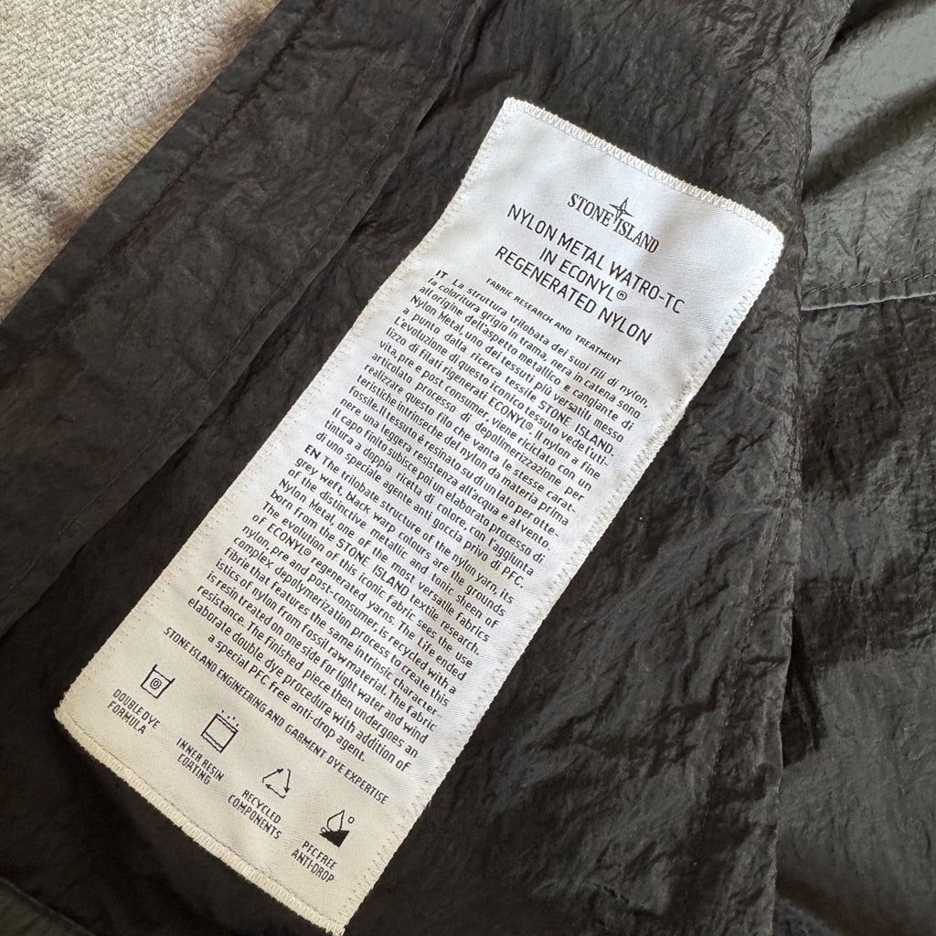 Stone Island black nylon metal Watro jacket with logo badge and visible wear marks.