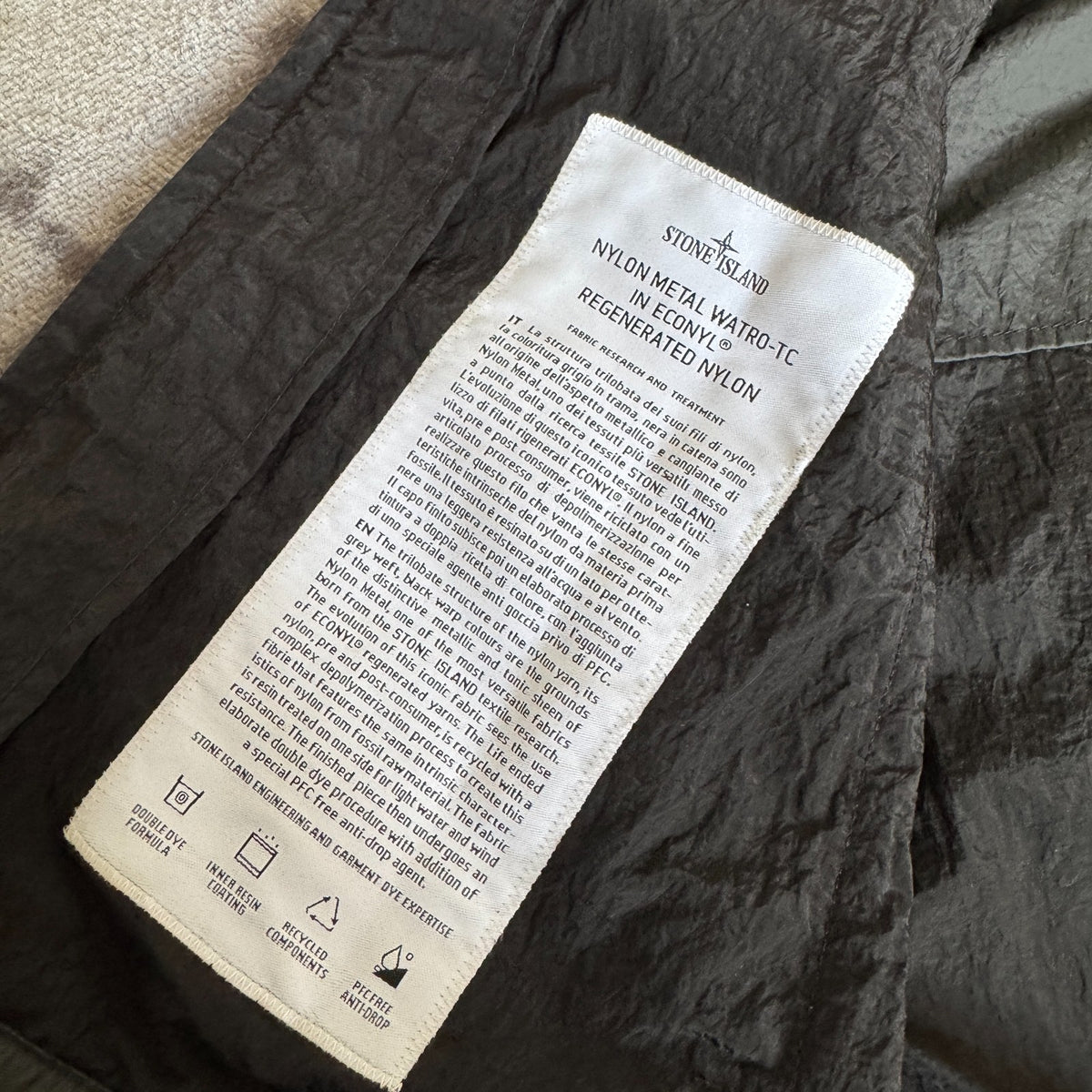 Stone Island black nylon metal Watro jacket with logo badge and visible wear marks.