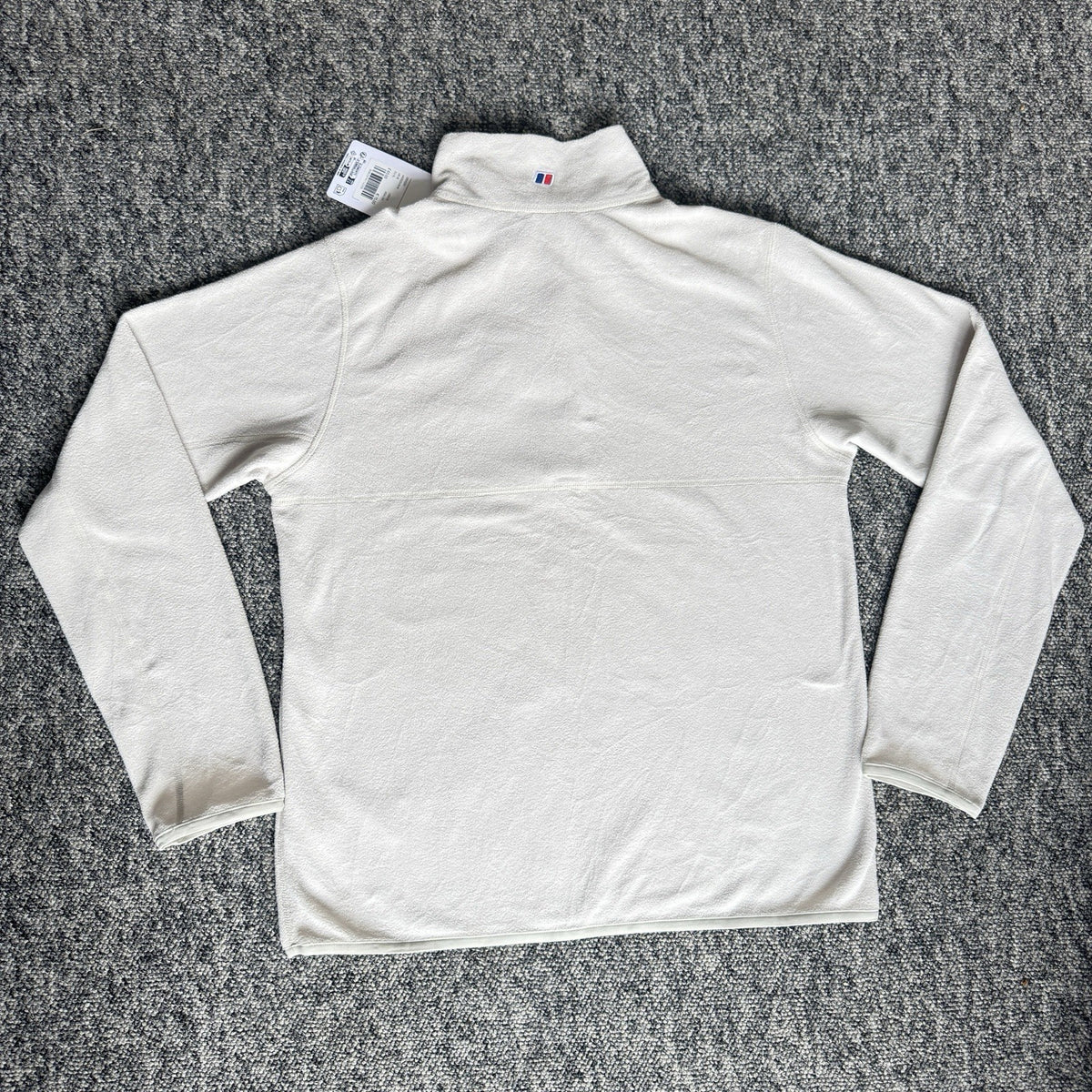 Berghaus off-white half-zip fleece with black logo pocket and stand-up collar.