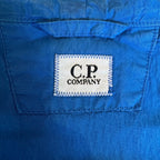 C.P. Company blue windbreaker jacket with big lens detail and garment-dyed finish.