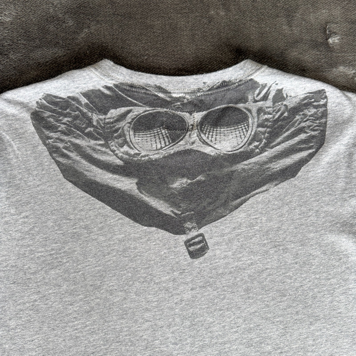 C.P. Company grey t-shirt featuring distinctive goggle print and logo detail.